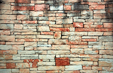 Antique red stone wall cobblestones with seamless masonry