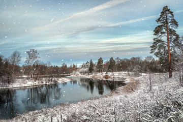 Winter landscape. Snowfall on the lake in the winter park.