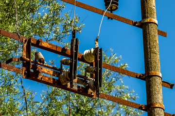 Old rusty electric equipment with clear blue sky and green blurred forest background near the Blue Eye water source in Albania. Sunny spring day