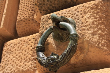 Bronze ring with an eagle head figure on the exterior wall of Charles V Palace at Alhambra Palace complex in Granada, Andalusia, Spain.