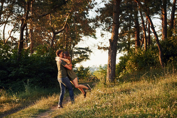 Beautiful young couple have a good time in the forest at daytime