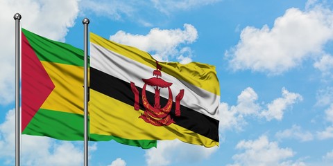 Sao Tome And Principe and Brunei flag waving in the wind against white cloudy blue sky together. Diplomacy concept, international relations.