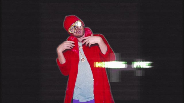 Mix Of Visual Effects. A Non-standard Young Man In A Red Coat Made Of Gold Chains Reads Rap. Bright Crazy Guy On The Background Of Various Effects. VFX 