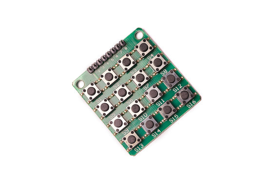 Lots of black little buttons on green PCB isolated on white background