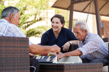 Professional helpful caregiver and a senior man during home visit