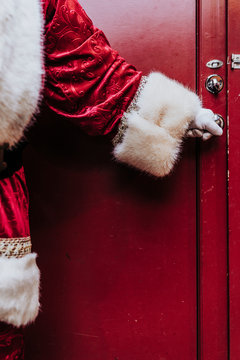 Santa Claus gloved hands open the door, close up