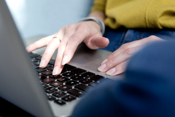 Woman's hand typing on keyboard, close-up