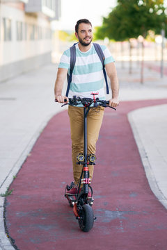Portrait of smiling man riding electric scooter