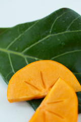 Macro of sliced persimmon fruit on marble background