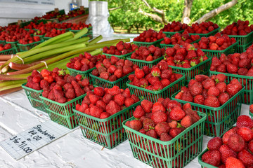 Fresh strawberries in the market are sold in plastic containers.