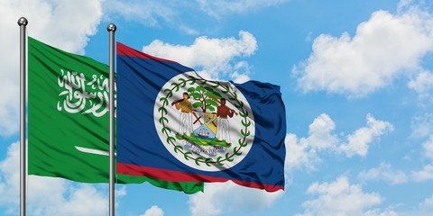 Saudi Arabia and Belize flag waving in the wind against white cloudy blue sky together. Diplomacy concept, international relations.