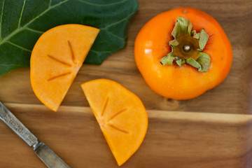 Macro of persimmon fruit on wooden board