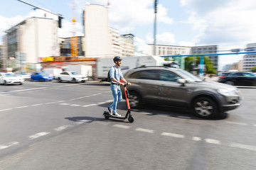 Businessman riding e-scooter on the street in the city, Berlin, Germany