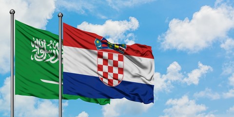 Saudi Arabia and Croatia flag waving in the wind against white cloudy blue sky together. Diplomacy concept, international relations.