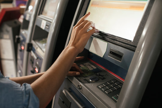 Young female, traveler buying ticket from automated machine at station