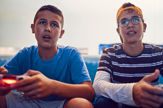 Portrait of teenage friends playing video game in an amusement arcade