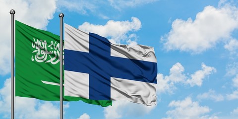 Saudi Arabia and Finland flag waving in the wind against white cloudy blue sky together. Diplomacy...