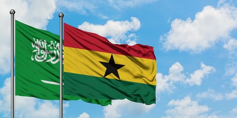 Saudi Arabia and Ghana flag waving in the wind against white cloudy blue sky together. Diplomacy concept, international relations.