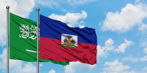 Saudi Arabia and Haiti flag waving in the wind against white cloudy blue sky together. Diplomacy concept, international relations.