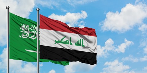 Saudi Arabia and Iraq flag waving in the wind against white cloudy blue sky together. Diplomacy concept, international relations.