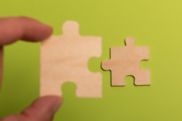 Man hand assembling puzzles on lime background