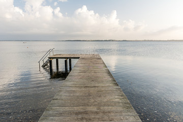 Fototapeta na wymiar Wooden pier at the calm Baltic Sea in scenic morning light