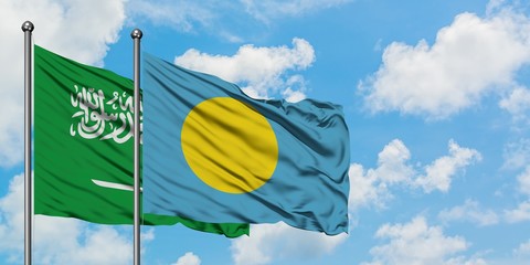 Saudi Arabia and Palau flag waving in the wind against white cloudy blue sky together. Diplomacy concept, international relations.