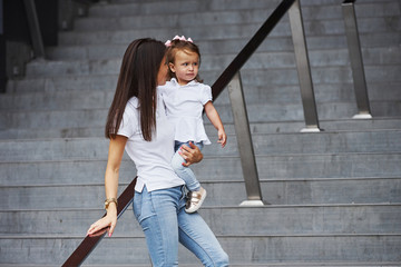 Pretty young mother and her little daughter have walk in the city