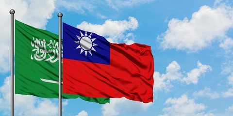 Saudi Arabia and Taiwan flag waving in the wind against white cloudy blue sky together. Diplomacy concept, international relations.