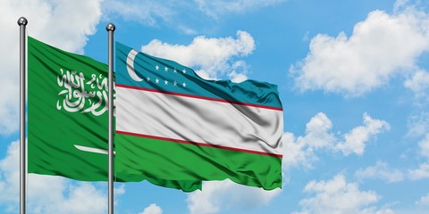 Saudi Arabia and Uzbekistan flag waving in the wind against white cloudy blue sky together. Diplomacy concept, international relations.