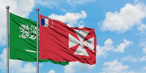 Saudi Arabia and Wallis And Futuna flag waving in the wind against white cloudy blue sky together. Diplomacy concept, international relations.