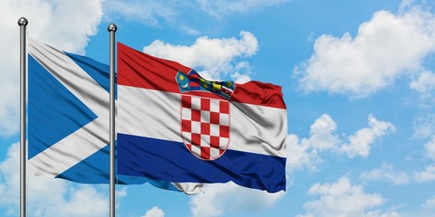 Scotland and Croatia flag waving in the wind against white cloudy blue sky together. Diplomacy concept, international relations.