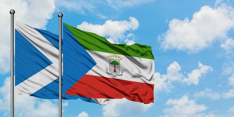 Scotland and Equatorial Guinea flag waving in the wind against white cloudy blue sky together. Diplomacy concept, international relations.