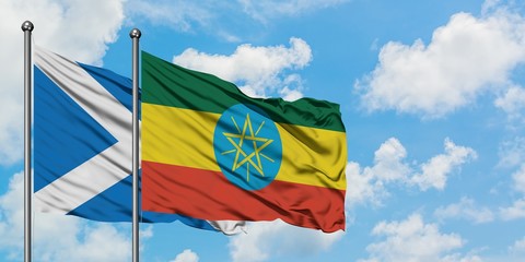 Scotland and Ethiopia flag waving in the wind against white cloudy blue sky together. Diplomacy concept, international relations.