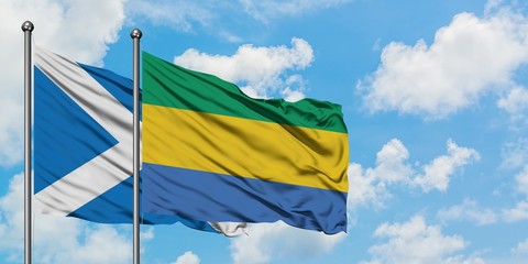 Scotland and Gabon flag waving in the wind against white cloudy blue sky together. Diplomacy concept, international relations.