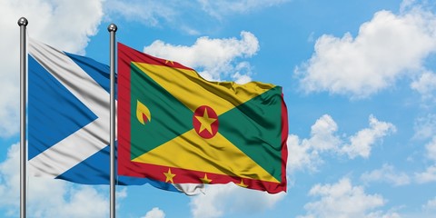 Scotland and Grenada flag waving in the wind against white cloudy blue sky together. Diplomacy concept, international relations.
