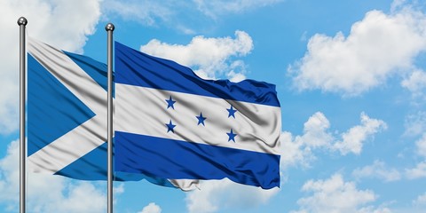 Scotland and Honduras flag waving in the wind against white cloudy blue sky together. Diplomacy concept, international relations.