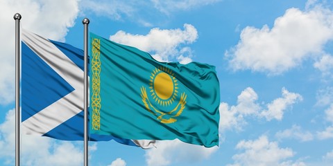 Scotland and Kazakhstan flag waving in the wind against white cloudy blue sky together. Diplomacy concept, international relations.