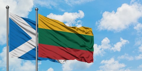 Scotland and Lithuania flag waving in the wind against white cloudy blue sky together. Diplomacy concept, international relations.