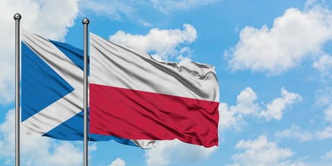 Scotland and Poland flag waving in the wind against white cloudy blue sky together. Diplomacy concept, international relations.