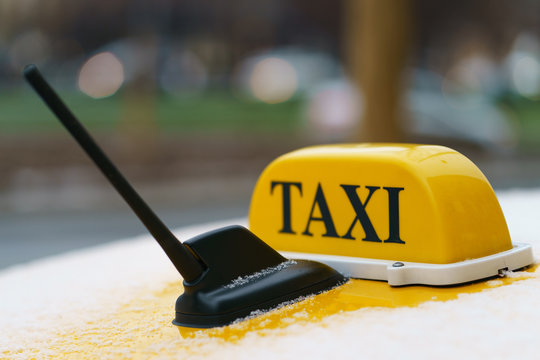 Photography of city taxi in the snowy autumn morning. Image with defocused background. Suitable for posters, greeting card.