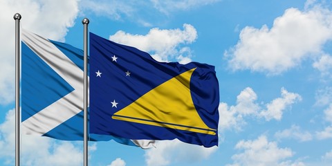 Scotland and Tokelau flag waving in the wind against white cloudy blue sky together. Diplomacy concept, international relations.