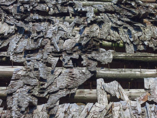 Destroyed wooden shingles on the old house. Roof made of wooden tiles