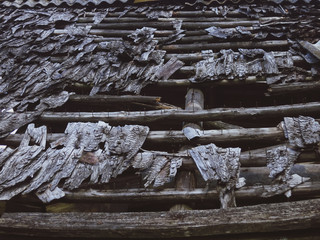 Destroyed wooden shingles on the old house. Roof made of wooden tiles