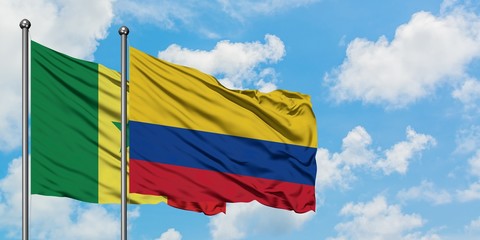 Senegal and Colombia flag waving in the wind against white cloudy blue sky together. Diplomacy concept, international relations.