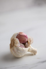Garlic bulb split open on marble background with copy space