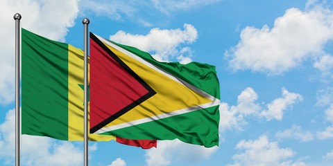 Senegal and Guyana flag waving in the wind against white cloudy blue sky together. Diplomacy concept, international relations.