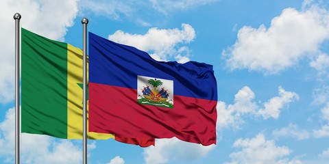 Senegal and Haiti flag waving in the wind against white cloudy blue sky together. Diplomacy concept, international relations.