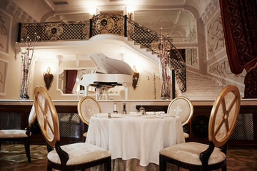 Table for the four people is ready to receive rich visitors. Interior of luxury restaurant in...