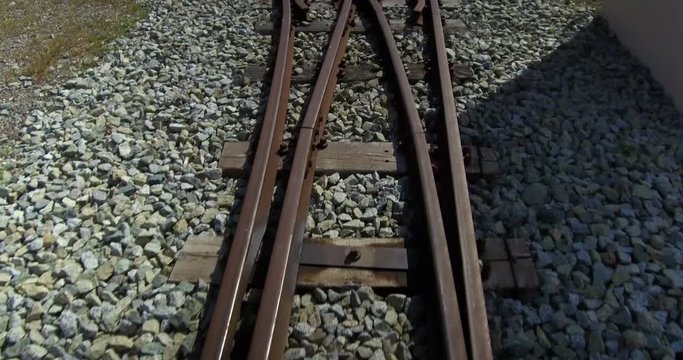 Subjective vision in motion over old train tracks. Narrow track, with old railroad switch and bifurcation of tracks.